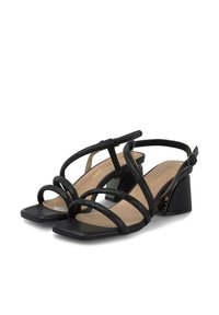Sandalias de tacón negro con punta cuadrada, que cuentan con correas entrelazadas de material suave y acentos texturizados, situadas sobre un tacón bajo de bloque.