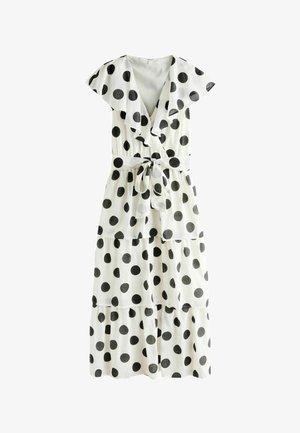 White tiered midi dress with black polka dots, short flutter sleeves, deep V-neck, and a matching waist tie belt.