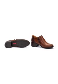 Bottines en cuir marron avec un petit talon carré, un design à enfiler et une semelle en caoutchouc texturé ornée d'un motif d'étoiles.