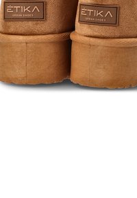 Zapatos de ante marrón con un diseño texturizado, suela de goma gruesa y etiquetas de marca en relieve en el talón.