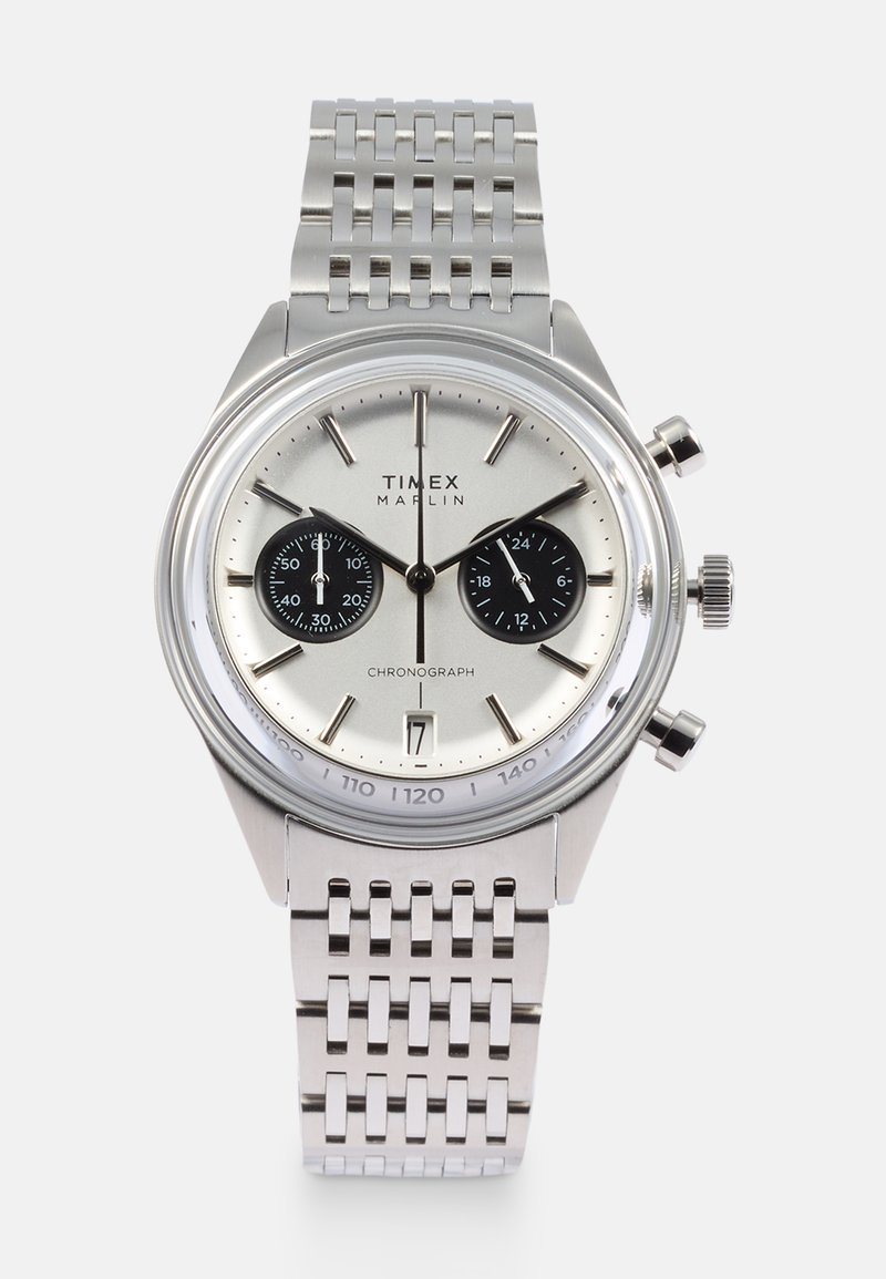 Sidabrinis nerūdijančio plieno chronografas laikrodis su juodais subdials, datos rodymas ir tinklinis apyrankė. Apvalus korpusas ir poliruotas paviršius.