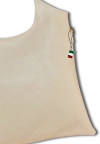 Beige leren handtas met een gladde textuur, voorzien van een klein Italiaans vlaggetje charm dat is bevestigd aan een gouden rits. Minimalistisch ontwerp met zachte randen.