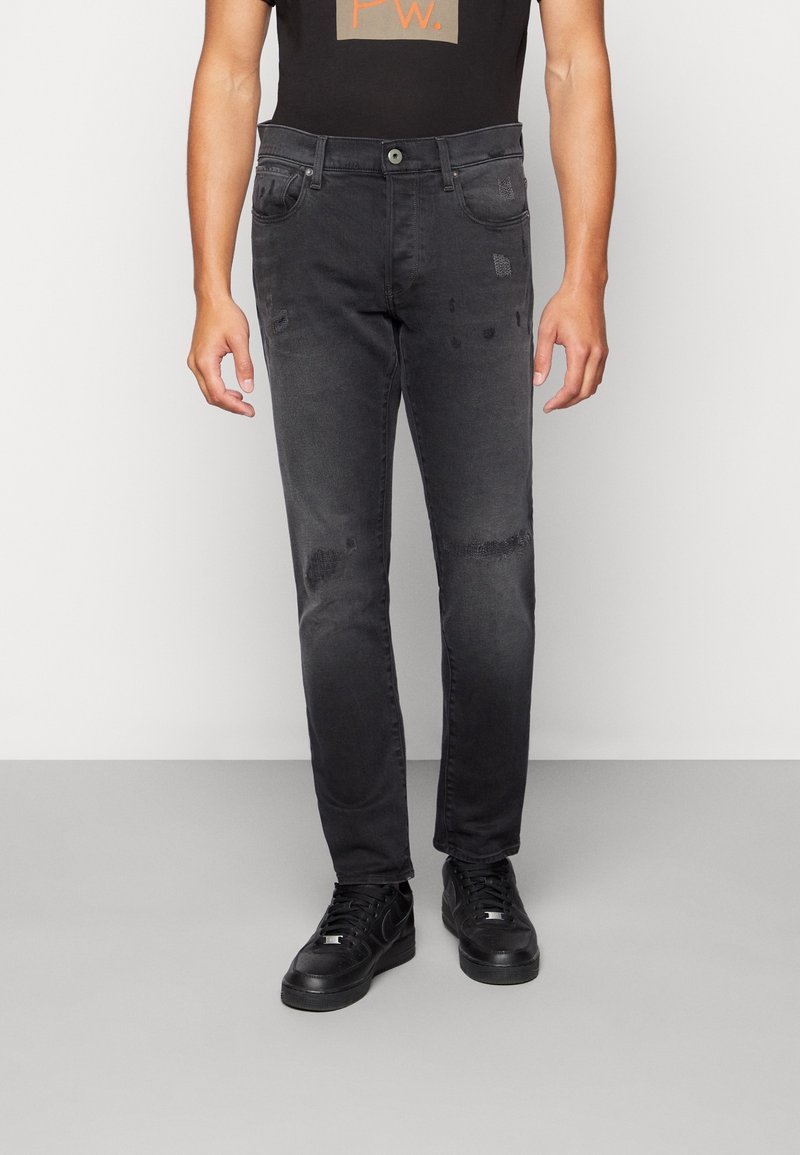 Svarta jeans i denim med slim fit, med subtila slitna detaljer och femficksdesign. Används med svarta sneakers.