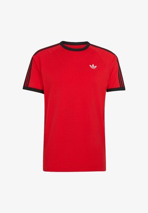 Czerwona koszulka Adidas z krótkim rękawem, czarnym kołnierzem i krawędziami rękawów, z trzema czarnymi paskami na rękawach oraz białym logo Adidas trefoil na piersi.