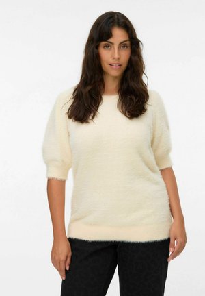 Maglione color crema con maniche corte e gonfie e una consistenza morbida e pelosa. Presenta un orlo e polsini a costine. Abbinato a pantaloni neri con motivo.