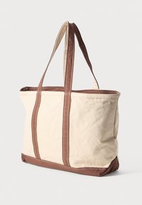 Saco de lona em bege com detalhes castanhos. Apresenta alças resistentes, costura em contraste e um interior espaçoso. Forma retangular clássica.