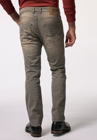 Jeans in denim grigio con vestibilità affusolata, caratterizzati da un'etichetta in pelle sulla vita, due tasche posteriori e dettagli di cucitura a contrasto.