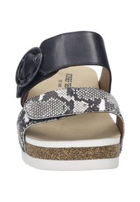 Zwarte leren slide sandaal met een grote cirkelvormige gesp, een slangenprint band, een gevoerd voetbed en een witte zool met kurkaccenten.