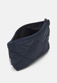 Bolsa de nylon acolchoada na cor azul-marinho com formato retangular, fecho com zíper e textura suave. Apresenta costura diagonal e um pequeno rótulo.