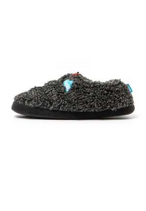 Zapatilla gris oscuro y peluda con una suela negra gruesa y etiquetas azules y rojas en la parte superior y trasera.