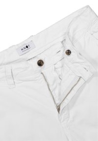 Białe bawełniane spodnie z zamkiem błyskawicznym, dwoma brązowymi guzikami i metką z napisem "NN07 No Nationality" na pasku. Gładka tekstura.