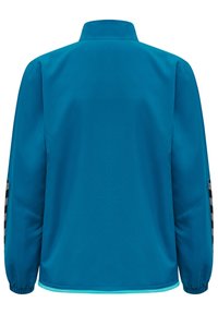 Chaqueta deportiva de color verde azulado con cuello alto, puños elásticos y acentos a rayas en negro y blanco en las mangas. Textura suave y diseño ligero.