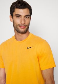 Nike Performance CREW SOLID - T-shirt desportiva - kumquat/black