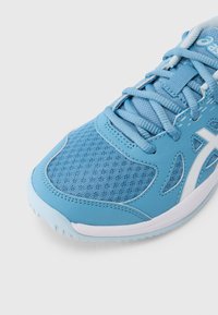 Αθλητικό παπούτσι ανοιχτού μπλε χρώματος με συνδυασμό διχτυού και συνθετικών υλικών, στρογγυλεμένο σχήμα, κορδόνια και διακριτικό λευκό λογότυπο στο πλάι.