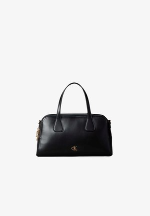 Sac à main en cuir noir avec deux poignées, fermeture éclair dorée et logo doré "cK" au centre avant.