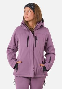 Lilla softshell-jakke med justerbar hætte, lynlåslommer og sorte accenter. Har en glat tekstur og tætsiddende design.