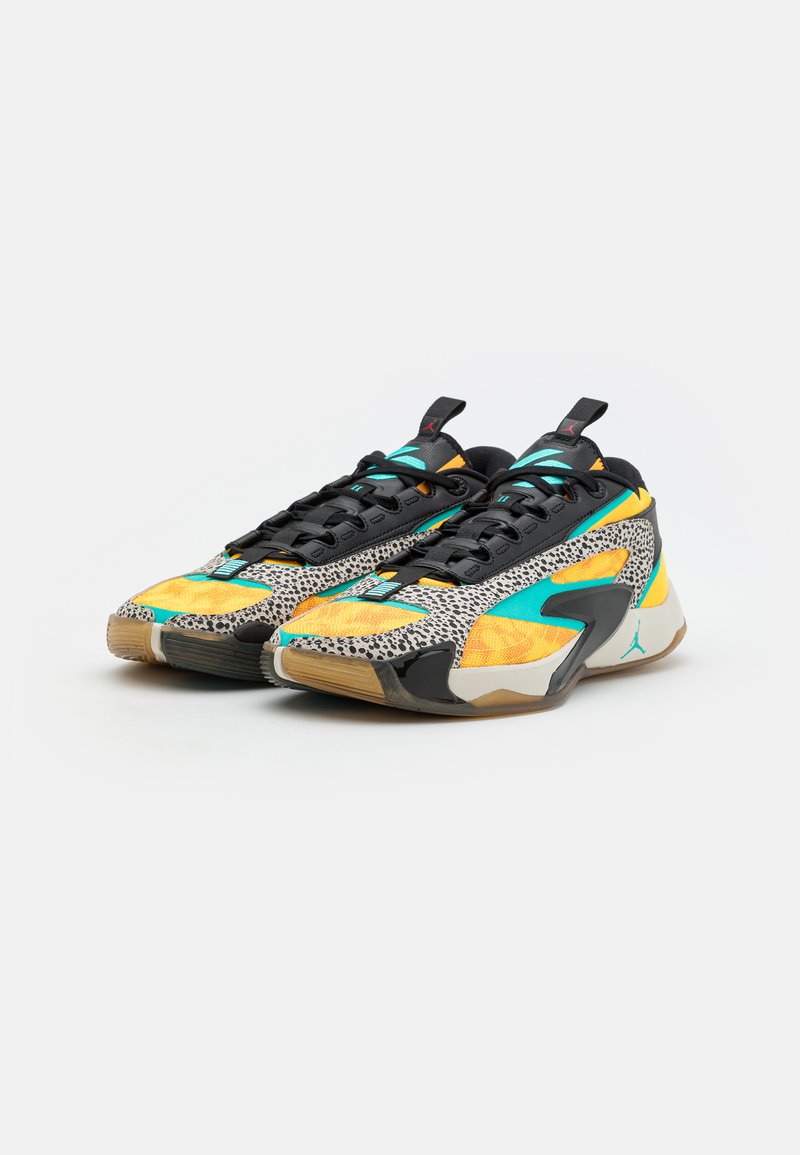 Des baskets avec une base noire, des accents orange et turquoise, des détails en imprimé léopard, et une semelle en caoutchouc à finition texturée.