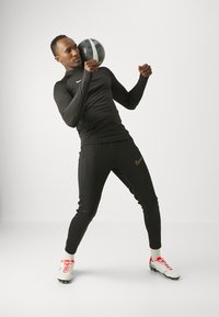 Nike Performance DRI-FIT ACADEMY PANT - Donji dijelovi trenirke - black/metallic gold