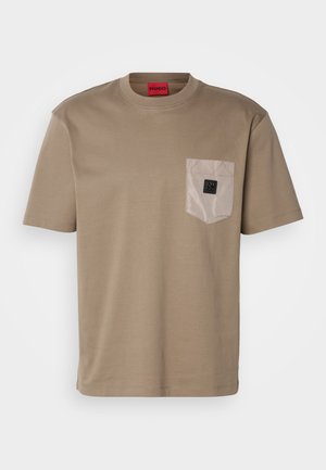 Beige T-shirt made of cotton, featuring a chest pocket in a contrasting light color and a small black logo on the pocket.