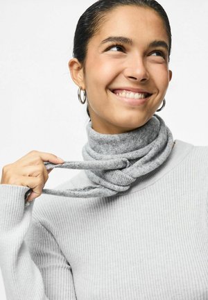 Grå strikket turtleneck med ribbet tekstur, der har et snoet gråt tørklæde omkring halsen, holdt af en hånd. Sølv-hulløreringe er synlige.