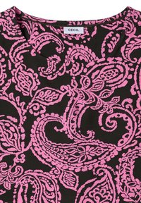 Tissu noir avec un motif paisley et floral rose vif et un col rond, étiqueté avec le nom de la marque « Cecil » sur le col.