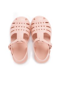 Sandales en plastique rose avec un design de lanières tressées et une sangle de cheville ajustable. Semelle intérieure texturée pour une bonne adhérence, semelle plate, style ouvert.