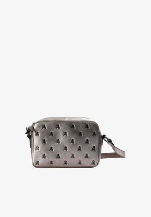 Bolso cruzado metálico plateado con patrón de calaveras en relieve. Forma rectangular, superficie texturizada, correa ajustable y cierre con cremallera.