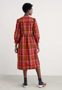 Rot, grün und gelb kariertes Midikleid mit langen Puffärmeln, geraffter Taille und geradem Rock. Leichter Baumwollstoff.