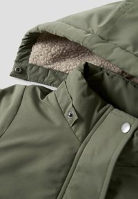 Giacca verde oliva con un morbido rivestimento in finta pelliccia color crema. Caratterizzata da un cappuccio, bottoni a pressione e un'esterno liscio e resistente all'acqua.