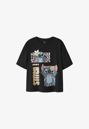 T-shirt noir avec deux images de Stitch, l’une faisant signe de la main et l’autre les bras levés, sur des fonds à imprimé léopard rose et texte doré « STITCH ! ».