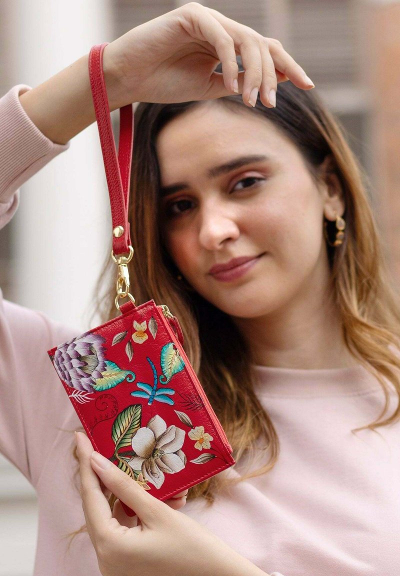 Rode leren portemonnee met bloemembroidery in roze, groen en blauw. Voorzien van een polsband en verguld beslag. Met ritssluiting.