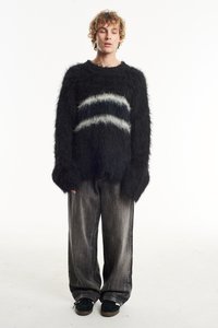 Black fluffy sweater with a white and gray striped pattern, paired with loose silver-gray pants and dark green footwear.