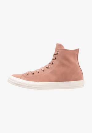 Basket montante en daim rose poudré clair avec semelle en caoutchouc blanche et lacets, vue de profil depuis le côté extérieur.