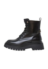 Stivaletto in pelle nera con suola in gomma spessa, punta rotonda, chiusura con lacci e linguetta sul retro, con un delicato dettaglio di branding.