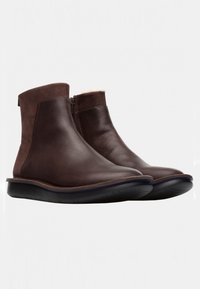 Botas de tobillo de cuero marrón con un acabado suave, cierre con cremallera lateral y suela de goma flexible. Diseño minimalista sin patrones adicionales.