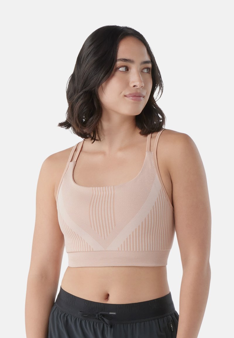 Sujetador deportivo de color rosa claro, hecho de tejido texturizado, con rayas verticales y diagonales, que cuenta con tirantes ajustables y un diseño corto.