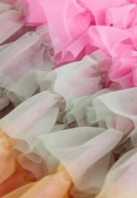 Večbarvna til tkanina z mehkimi roza, zelenimi in oranžnimi volančki. Prosojna tekstura z nabranimi robovi za plasten videz.