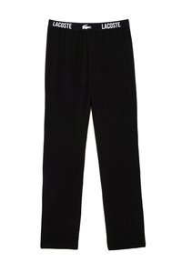 Schwarze Baumwollleggings mit einem elastischen Bund, auf dem das Lacoste-Logo in Weiß abgebildet ist. Das Design ist einfach und hat einen geraden Schnitt.