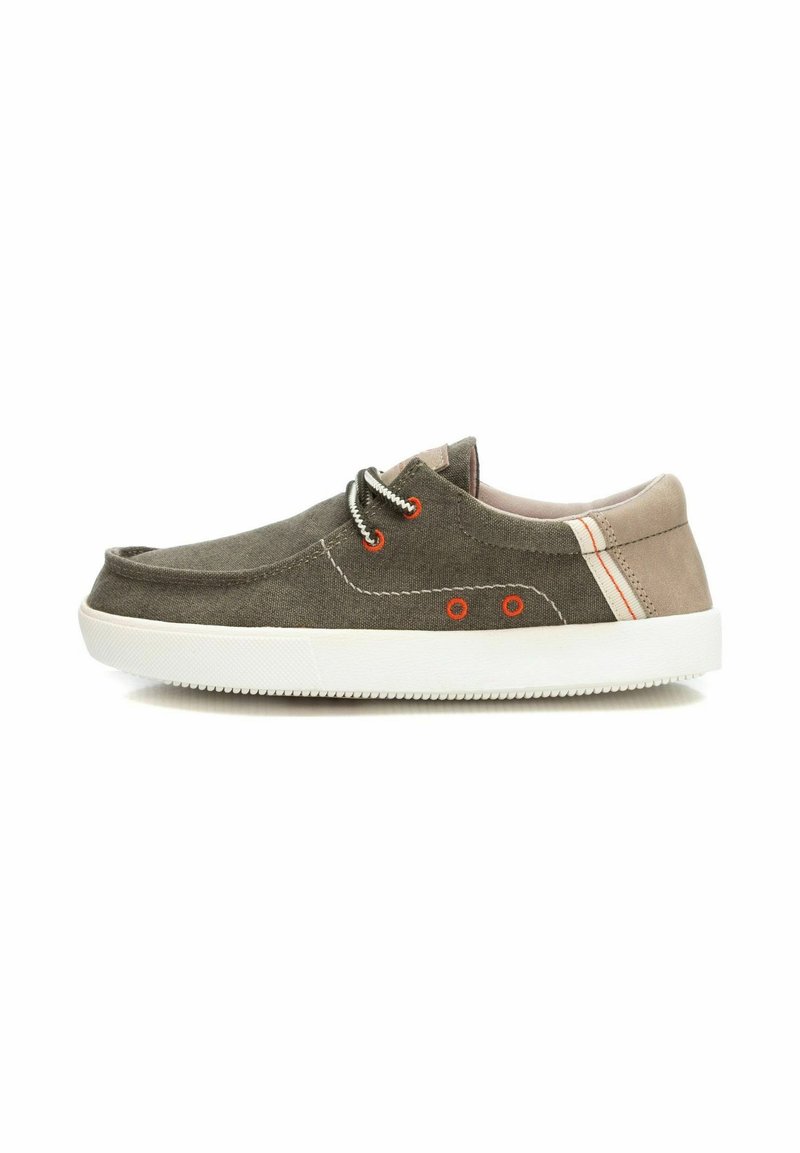 Zapatillas de lona en verde oliva, con suelas de goma blanca, ojales naranjas y detalles en crema en el talón. Punta redonda con diseño de cordones.