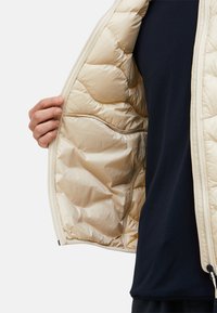 Helles beige Puffer-Weste mit glänzender, gesteppten Oberfläche. Das Innere ist glatt und weich und verfügt über eine Seitentasche und einen Reißverschluss in voller Länge.