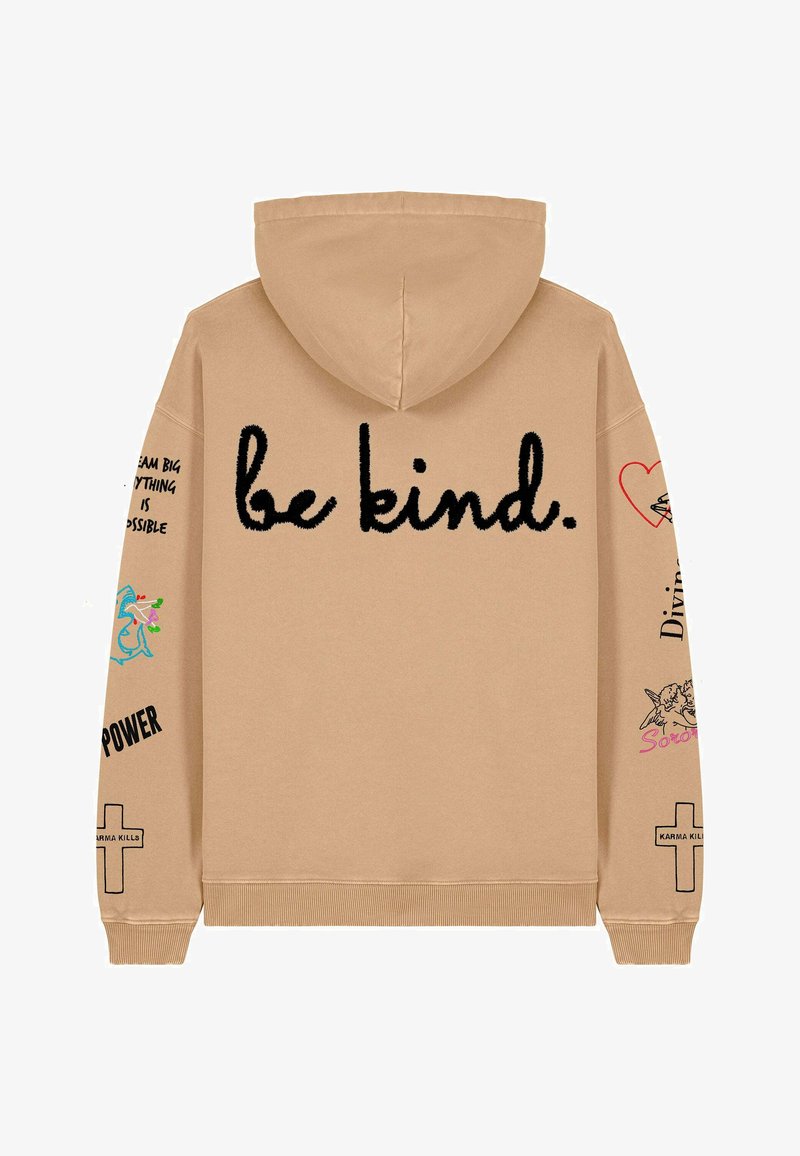 Bež dukserica s kapuljačom na kojoj je crnim vezom na leđima ispisano "budite ljubazni". Ukrašena raznim grafičkim motivima i tekstovima na rukavima. Mekana tekstura.