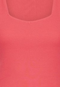 Gros plan d'un tissu côtelé avec un col arrondi de couleur corail rose, montrant une fine texture verticale et des détails de couture.