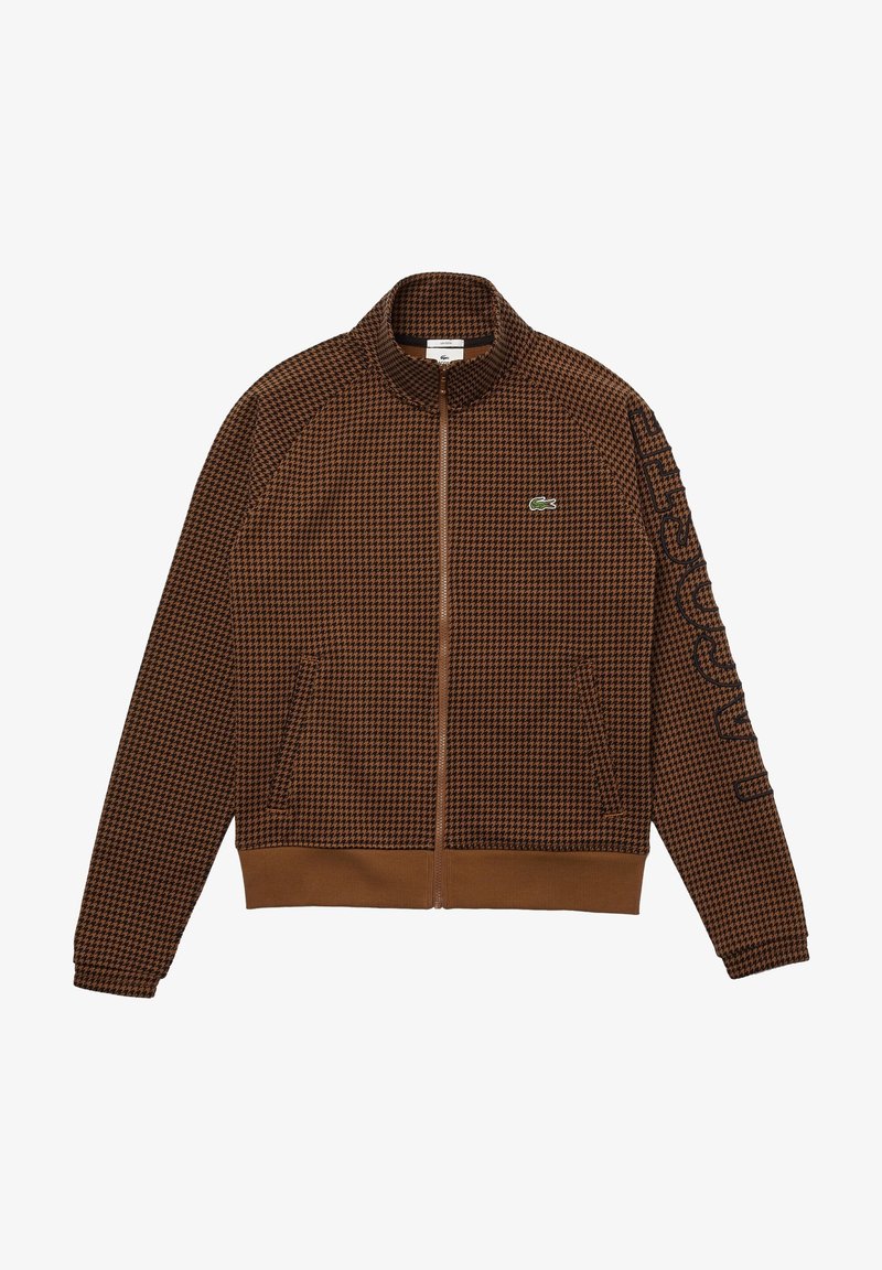 Ruskea ruudullinen vetoketjullinen takki, jossa on korkea kaulus, sivutaskut, resoroitu vyötärönauha ja vihreä Lacosten logo rinnassa.