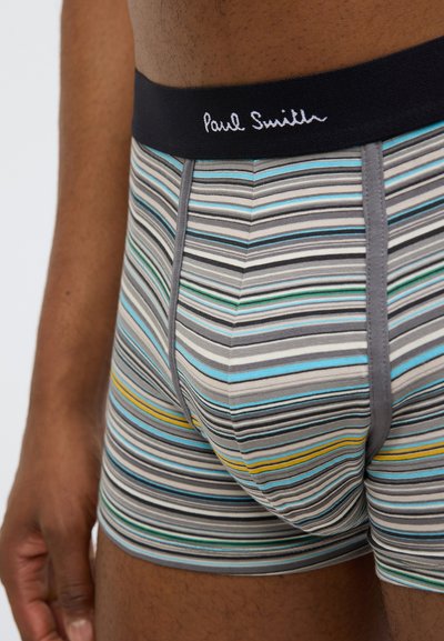 Boxer-briefs pour hommes en gris avec des rayures horizontales multicolores. Ils comportent une ceinture noire avec le logo "Paul Smith". Mélange de coton doux et élastique.