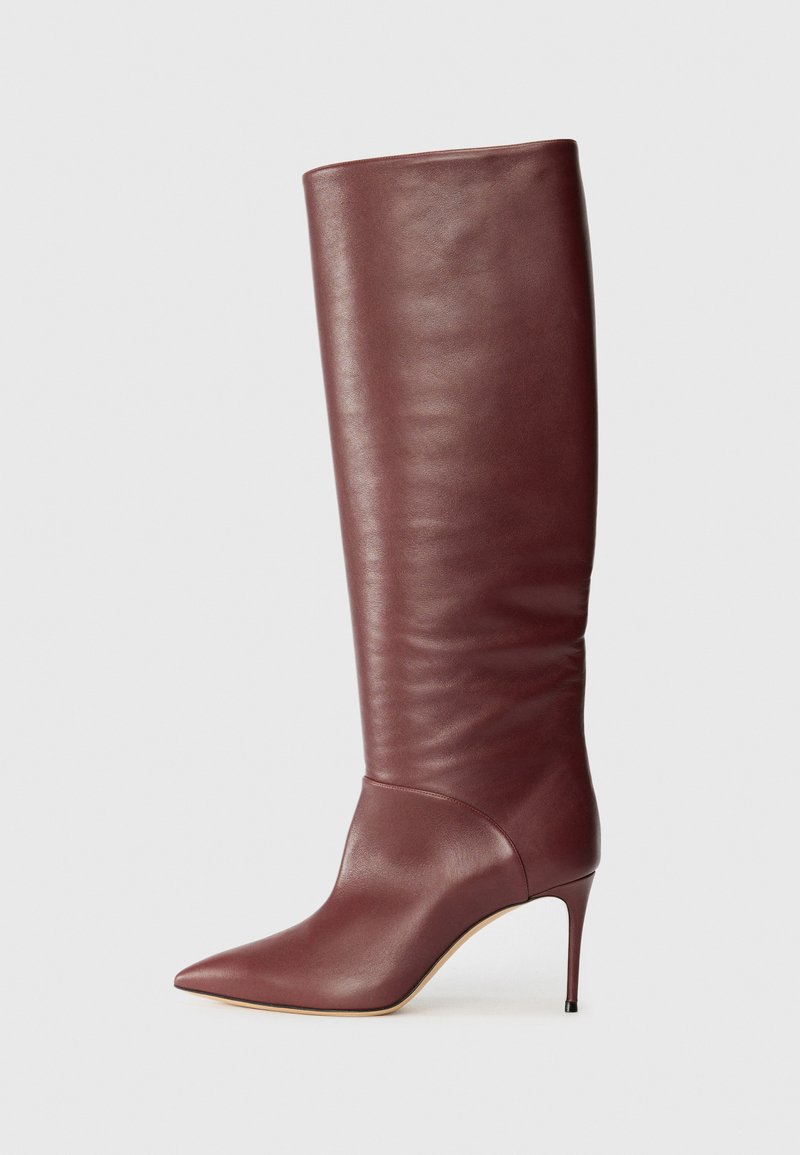 Burgundibőr térd feletti csizmák hegyes orral és tűsarokkal. Sima textúra, minimális részletezéssel és testéhez simuló siluettel.