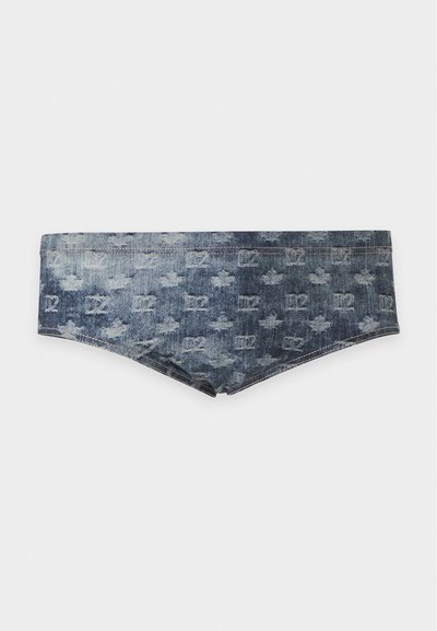 Slip de bain style denim bleu foncé avec motifs monogramme légèrement délavés et ceinture droite sur fond blanc.
