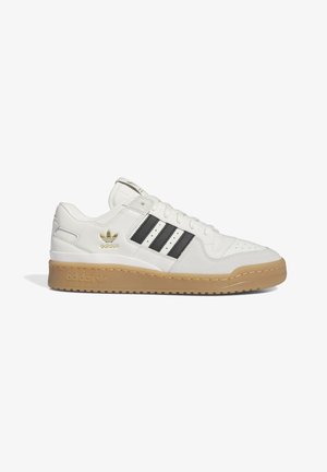Białe niskie buty sportowe Adidas z czarnymi paskami, gumową podeszwą i złotym logo Adidas z boku, widziane od zewnętrznej strony.