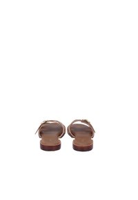 Bruine leren sandalen met een platte zool, dunne banden en een klein detail van een gouden gesp. Gladde textuur en een minimalistisch ontwerp.