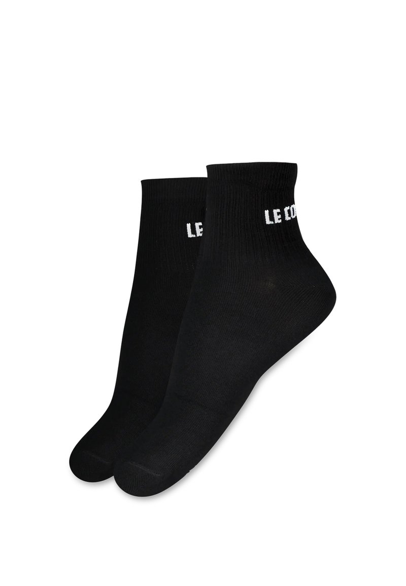 Calcetines de algodón negros hasta el tobillo con textura acanalada y la marca blanca "LE COQ" en el puño. Forma de puntera estándar con costuras reforzadas.