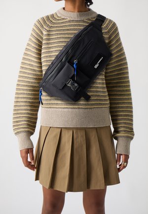 Černá crossbody taška s několika zipovými kapsami, modrými zipovými úchyty a bočním klipem. Hladký tkaninový povrch s elegantním designem.